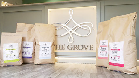 Reception desk centre panel with shiny mirror-finish chandelier logo and several brown bags of food with different colour labels
