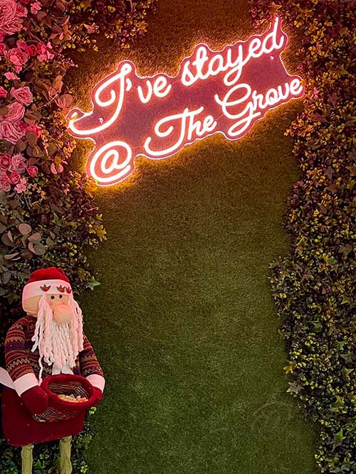 Father Christmas figure holding a bowl of dog treats in front of the Selfie Wall