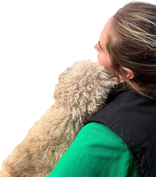 Canine Carermember cuddling Bichon Frise dog